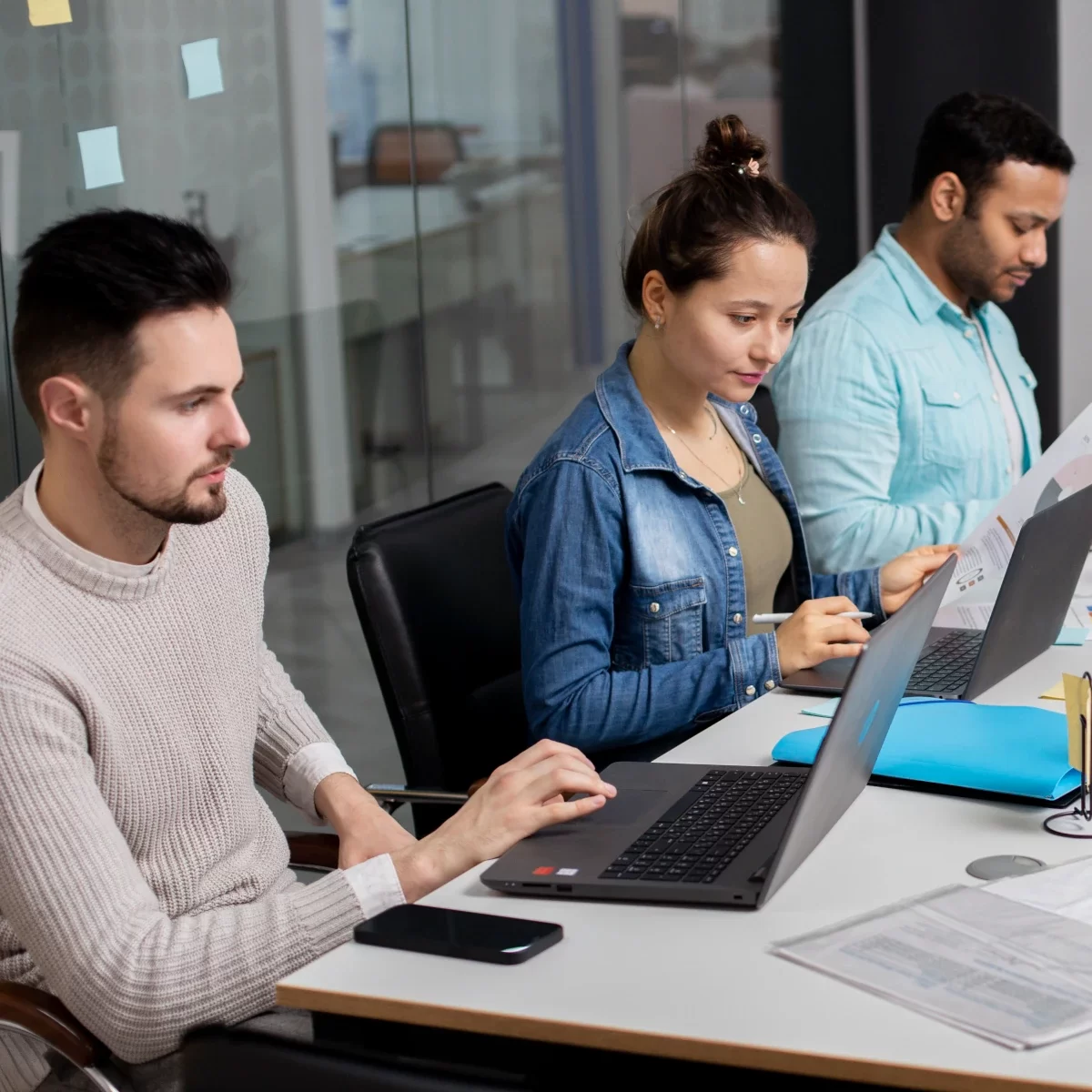 Group of people working on several desktop computers